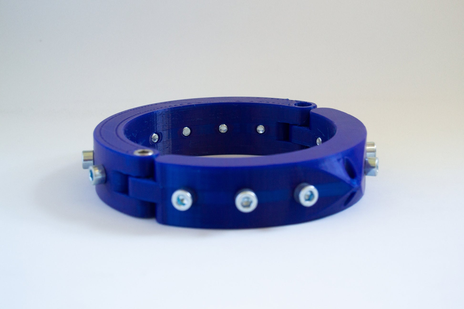 Blue 3d printed bdsm collar adorned with bolts from the side